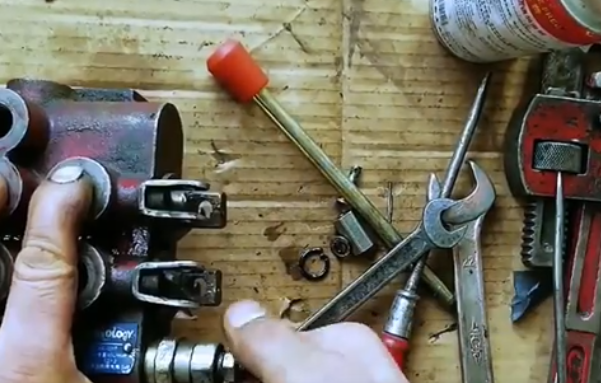 Technician performing maintenance on hydraulic valve components